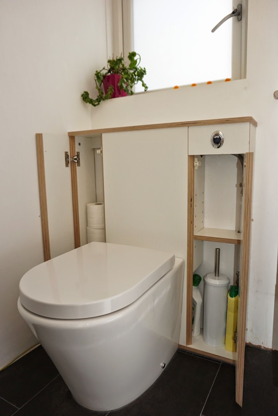 Both doors open, showing the brush and toilet rolls