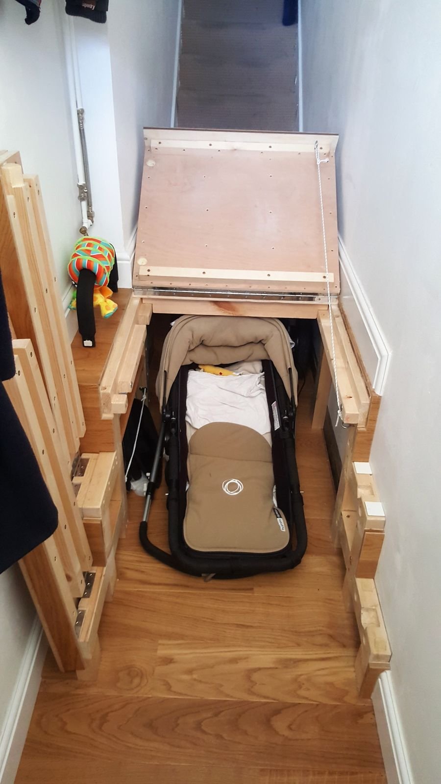 A folded pram stored under the raised floor