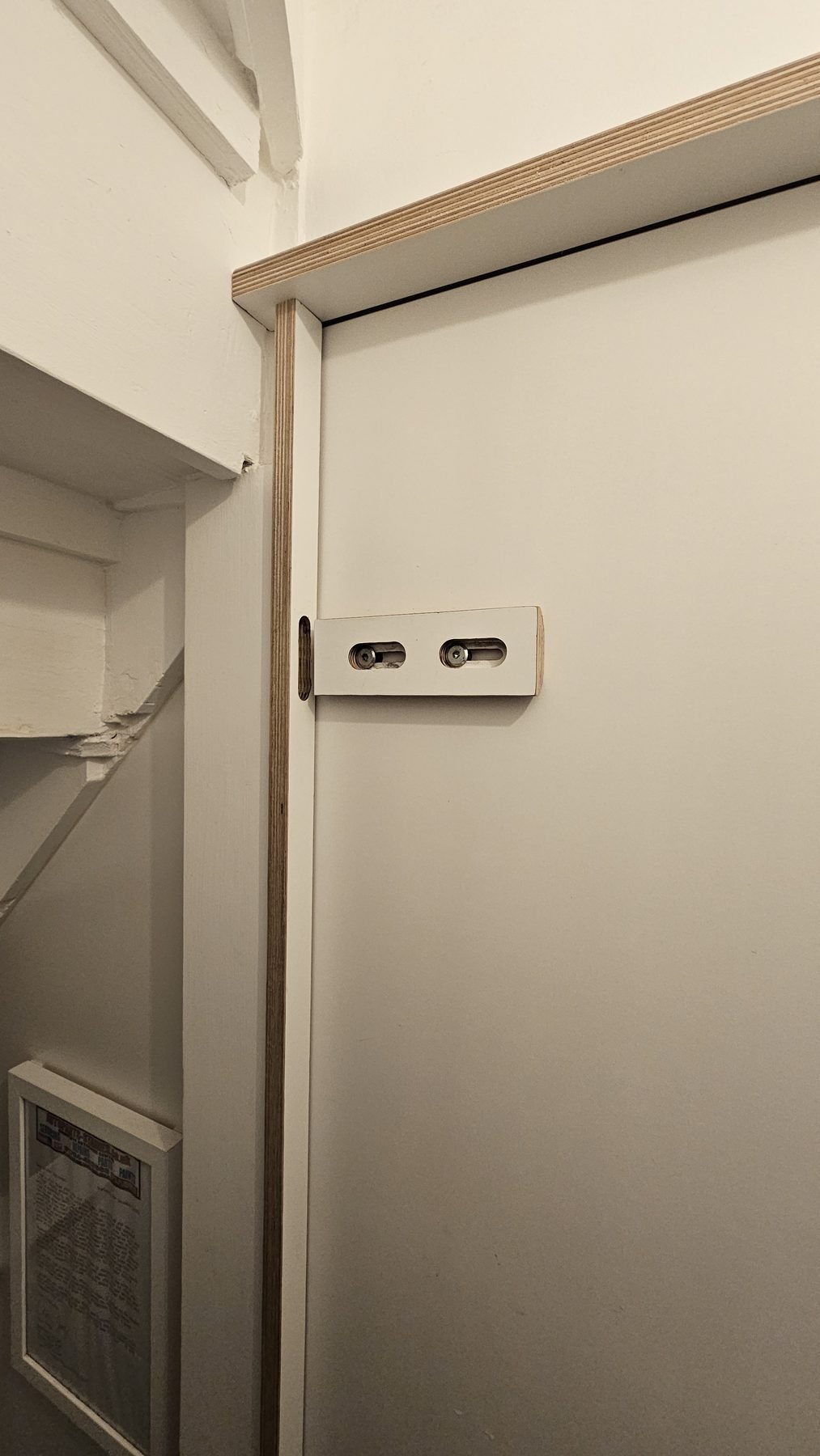 Plywood sliding lock on the inside of the toilet door, open