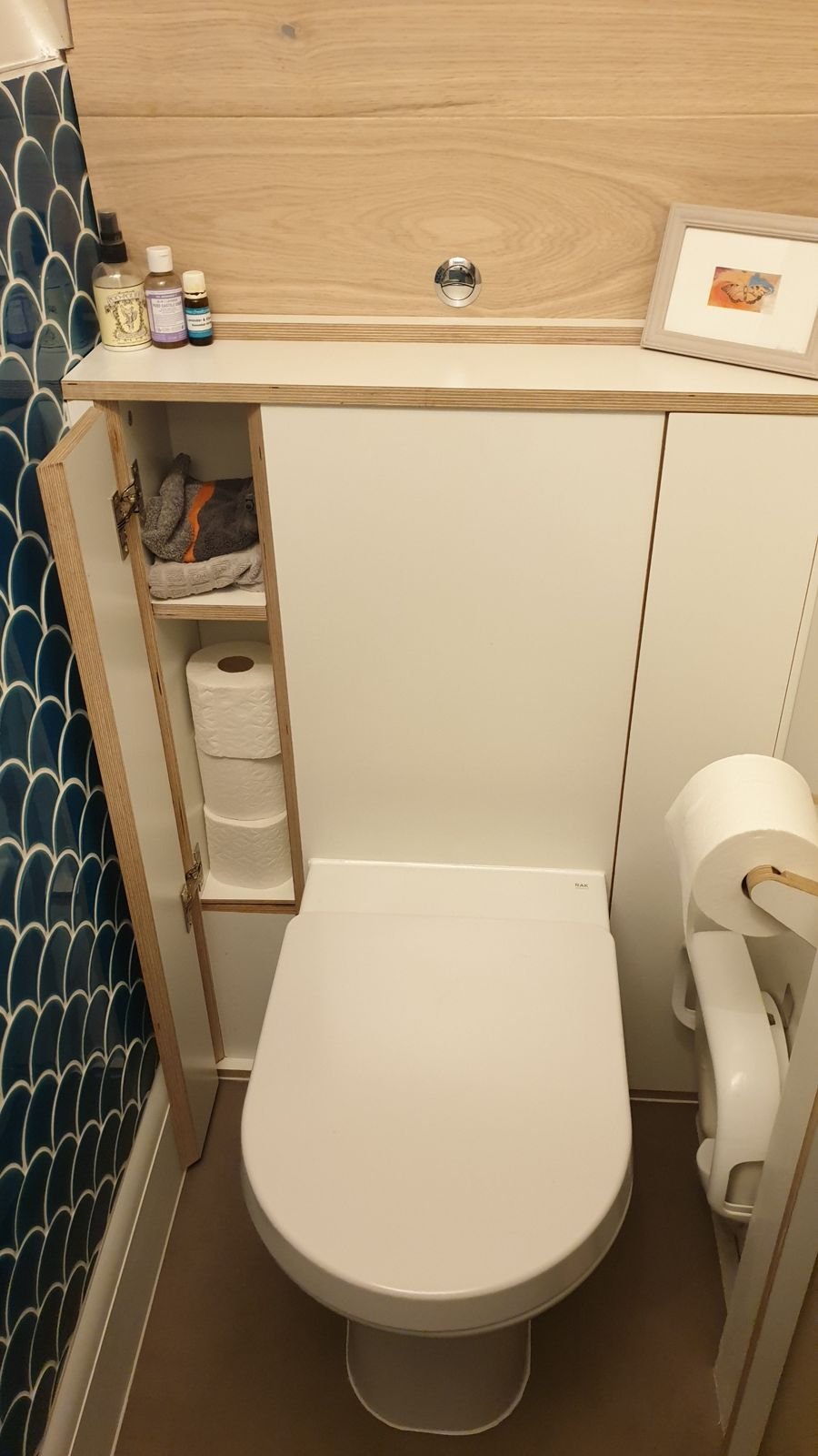 One of the angled doors open showing toilet rolls inside
