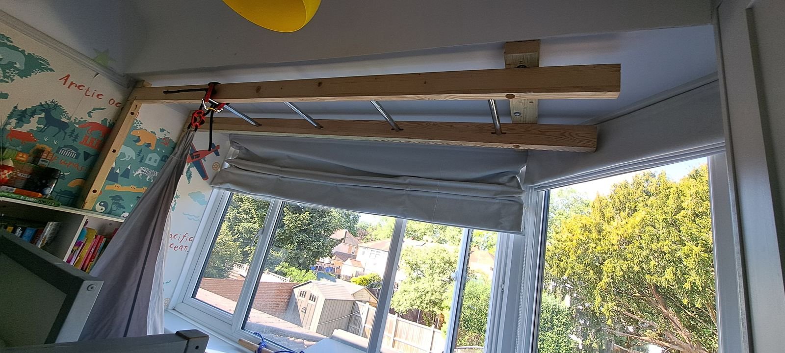 Timber monkey bars running across a bedroom ceiling by the bay window