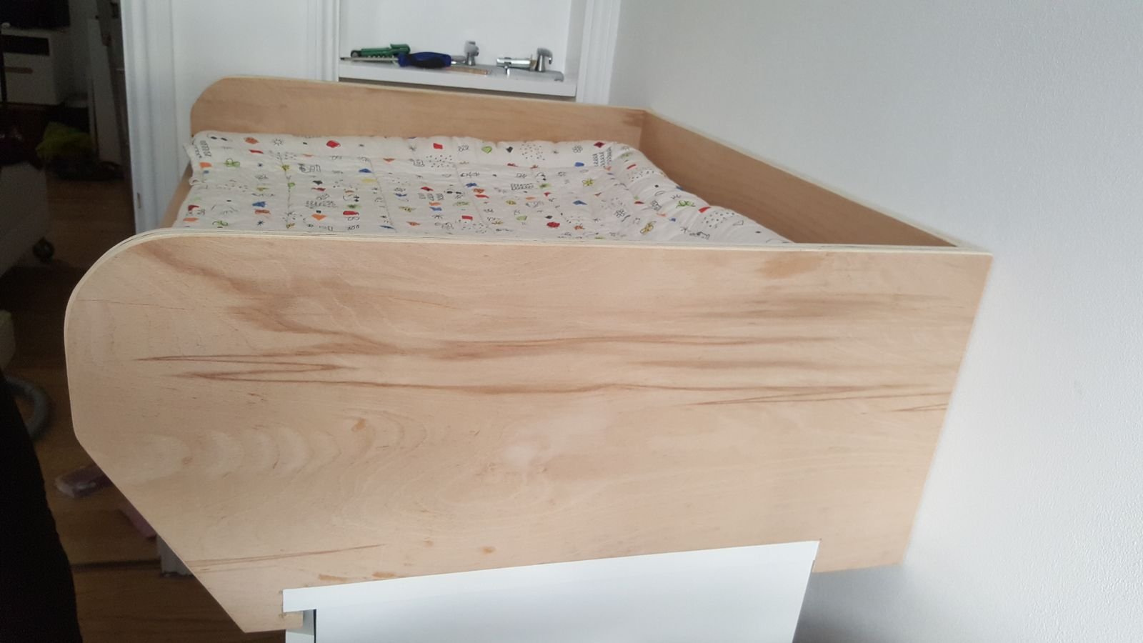 The plywood side panel with a notch cut to fit over the IKEA drawers